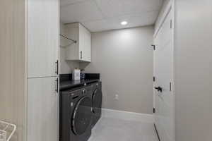 Laundry area featuring cabinet space, washer and dryer, recessed lighting, baseboards, and light tile patterned flooring