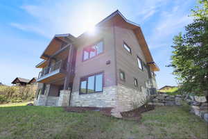 View of property exterior with a balcony and stone siding