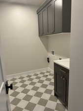 Washroom featuring light floors, cabinet space, and washer hookup