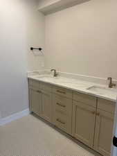 Bathroom with double vanity and baseboards