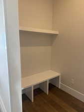 Mudroom featuring dark wood-style flooring and baseboards