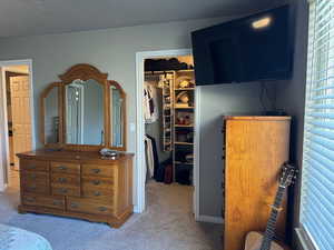 Bedroom with a walk in closet, carpet, and a closet