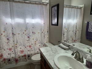 Full bathroom with vanity, toilet, and tile patterned flooring