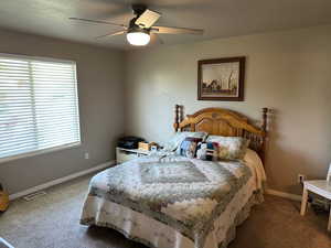 Bedroom with carpet flooring, baseboards, and a ceiling fan