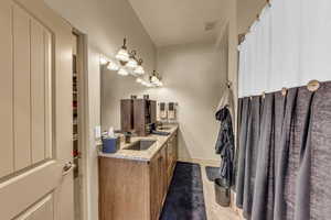 Full bath featuring tile patterned flooring, double vanity, and baseboards
