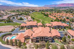 Aerial perspective of suburban area with a mountain backdrop and a golf course