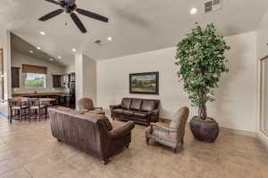 Living area featuring light tile patterned flooring, lofted ceiling, recessed lighting, and a ceiling fan