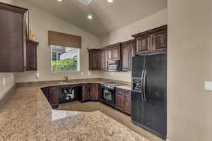 Kitchen with black appliances, a sink, dark brown cabinetry, vaulted ceiling, and recessed lighting