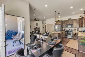 Dining area with dark wood-style floors, recessed lighting, a ceiling fan, and arched walkways