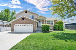 Tri-level home featuring brick siding, driveway, and a 2 car garage!