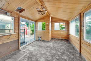 Unfurnished sunroom featuring vaulted ceiling