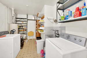 Laundry room with gas water heater, light flooring, and separate washer and dryer