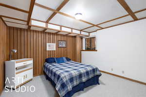 Bedroom featuring baseboards, carpet flooring, and wooden walls