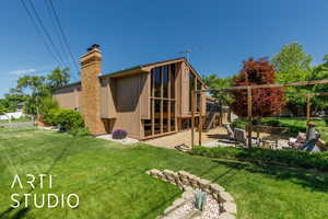 Rear view of property with a patio, stairway, a chimney, and a yard