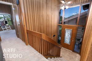 Entryway with wooden walls and ceiling fan