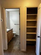 Bathroom with vanity, toilet, and baseboards