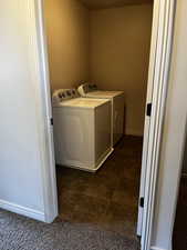 Washroom with washing machine and clothes dryer and baseboards