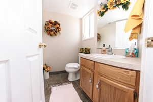 Bathroom with vanity, toilet, and tile patterned flooring