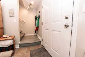 Entryway with stairs and baseboards