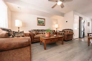 Living room with a ceiling fan and wood finished floors