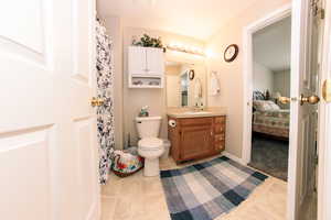 Bathroom featuring tile patterned floors, vanity, ensuite bath, and toilet