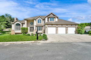 View of front facade with concrete driveway, a front lawn, and a garage
