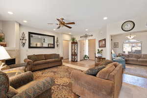 Living room featuring ceiling fan, recessed lighting, and a high end fireplace