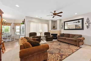 Living area with ceiling fan, carpet floors, recessed lighting, baseboards, and a fireplace