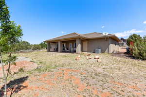 Back of property featuring stucco siding, a patio area, and cooling unit