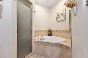 Bathroom featuring a stall shower, a bath, and tile patterned flooring