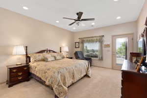 Bedroom with light colored carpet, access to exterior, recessed lighting, and baseboards