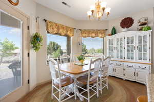 Carpeted dining room with a chandelier