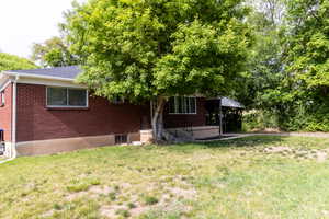 View of front facade featuring a front yard and brick