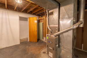 Laundry room with extra storage closet with furnace and water heater