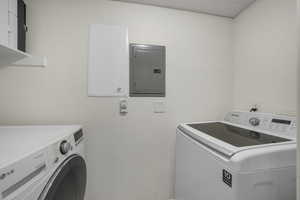 Laundry area featuring electric panel and washing machine and dryer