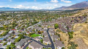 Aerial view of property and surrounding area featuring nearby suburban area and mountains