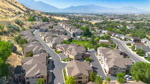 Aerial view of property's location with nearby suburban area and a mountainous background