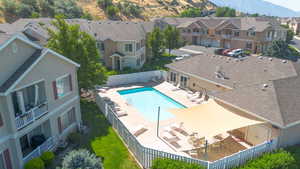Community pool featuring a residential view, a mountain view, a patio, and a fenced backyard