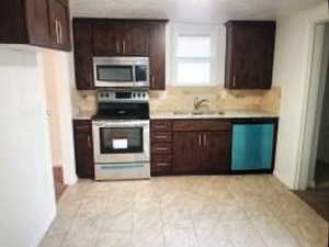 Kitchen with stainless steel appliances, light countertops, a sink, dark brown cabinets, and decorative backsplash