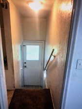 View of staircase to basement and backyard