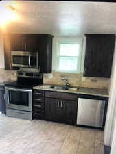 Kitchen with stainless steel appliances, a sink, and backsplash