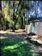 View of backyard with deep one car garage ( garage gate and individual entrance door )  and one storage room.
