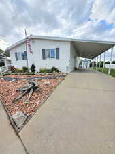 Manufactured / mobile home with concrete driveway and an attached carport