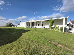 Back of house featuring a yard and a sunroom