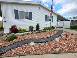 View of side of property featuring a carport and concrete driveway