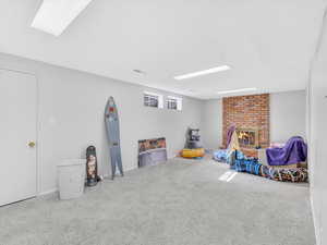 Rec room with carpet, a fireplace, and baseboards