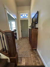 Entrance foyer with dark wood finished floors, baseboards, and stairs