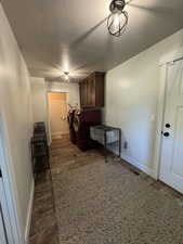 Laundry area featuring cabinet space, baseboards, and a textured ceiling