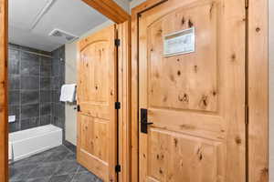 Full bath featuring tile patterned flooring and shower / bathtub combination