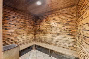 Sauna / steam room featuring tile patterned flooring, wood walls, and wood ceiling